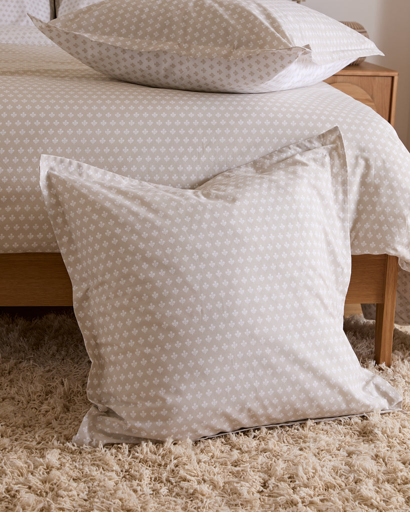 Patterned pillow on a bed with a neutral color scheme