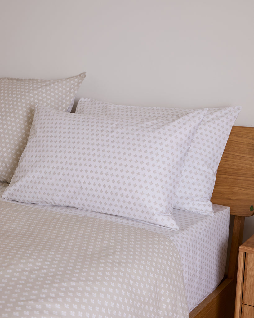 White textured pillows on a bed with a wooden headboard.